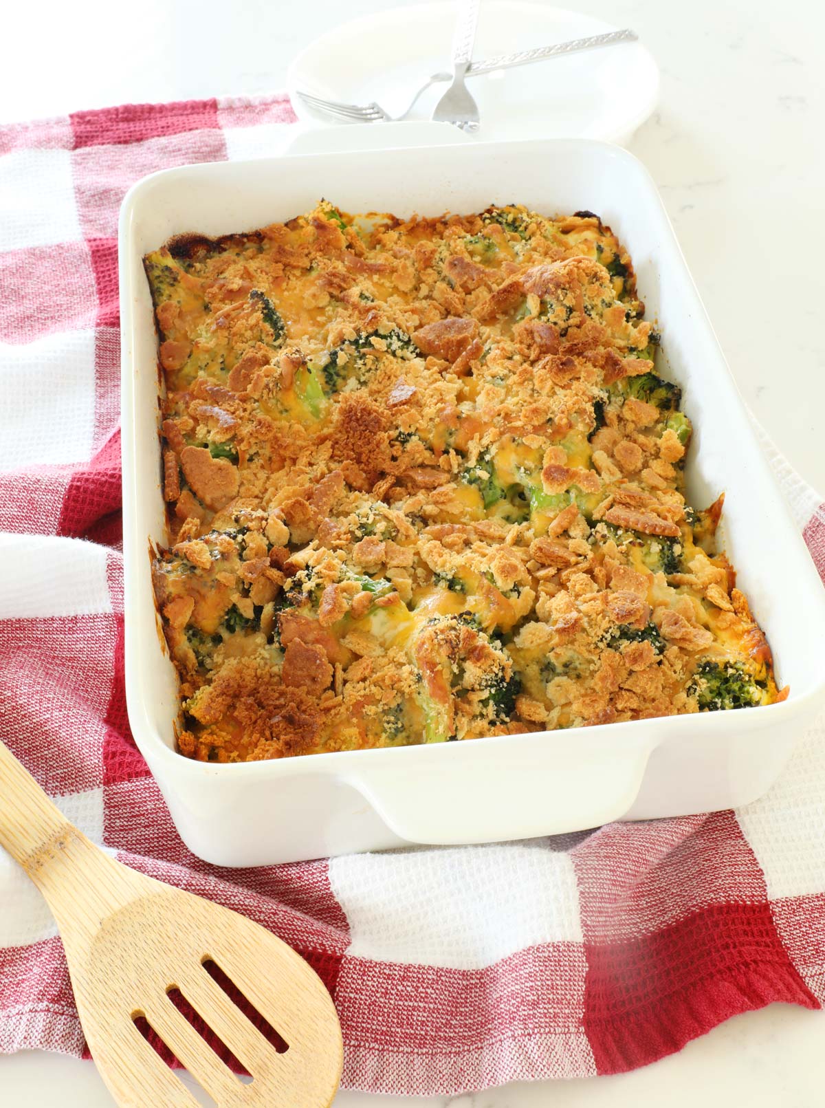 Broccoli Casserole in a baking dish on a red and white kitchen towel.