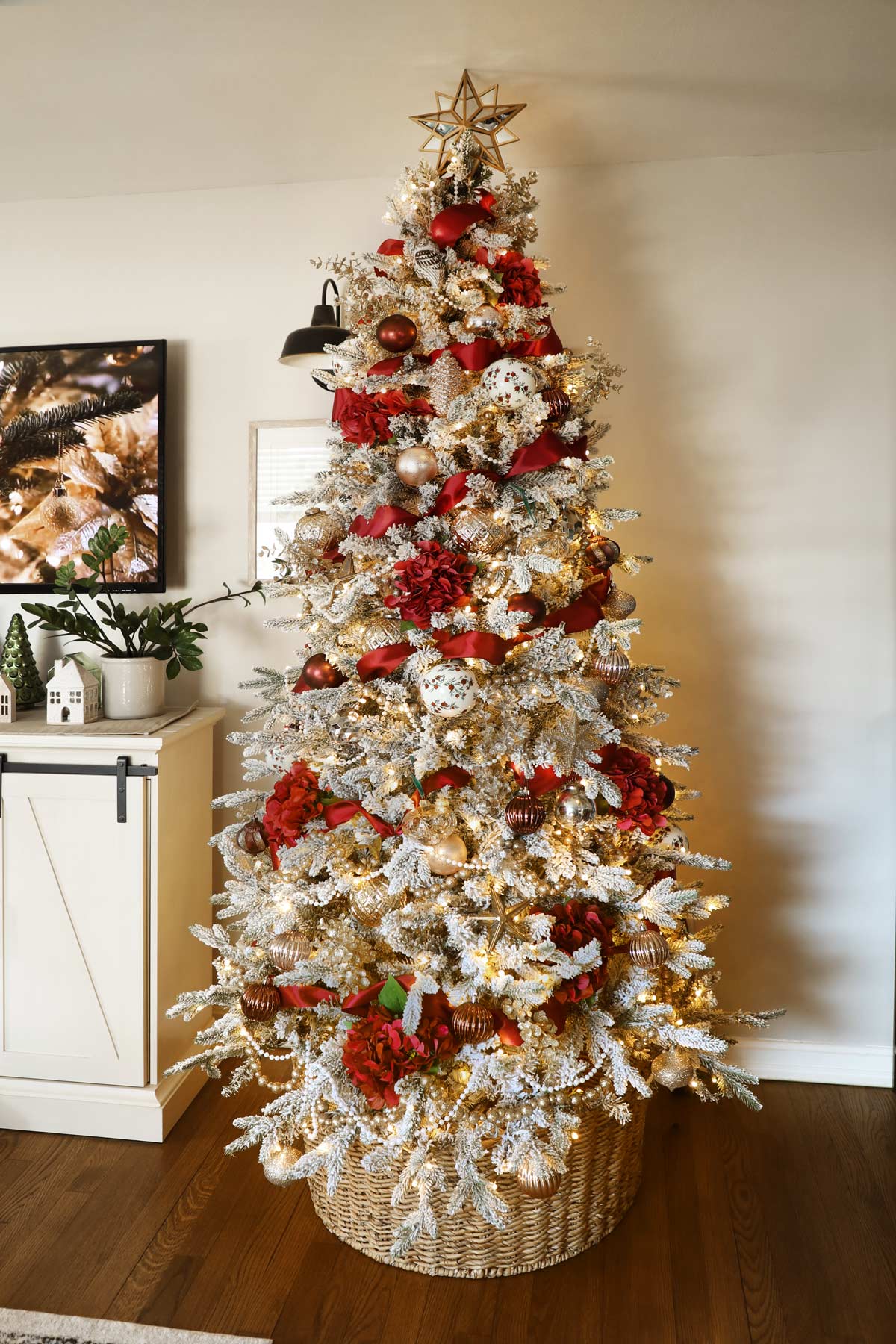 Elegant Christmas tree with strings of pearls, gold beads, maroon ribbon, red floral accents and gold ornaments, Gold Star tree topper.