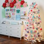 A beautiful white christmas tree with colorful ornaments in a craft room.