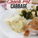 Crock pot cabbage, broccoli and cauliflower, and pork chops sit on a white plate, with the crock pot cabbage centered in frame.