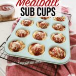 Meatball cups sitting in a teal muffin tin on the kitchen counter, marinara dipping sauce sits in a bowl off the the side.