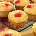 Piña colada muffins on a wire cooling rack in a kitchen.